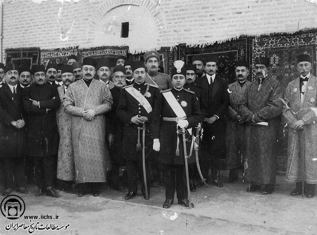 احمدشاه و محمدحسن‌میرزا ولیعهد در لباس رسمی به اتفاق رضاخان و احمد قوام‌السلطنه و عده‌ای از رجال و دربار 