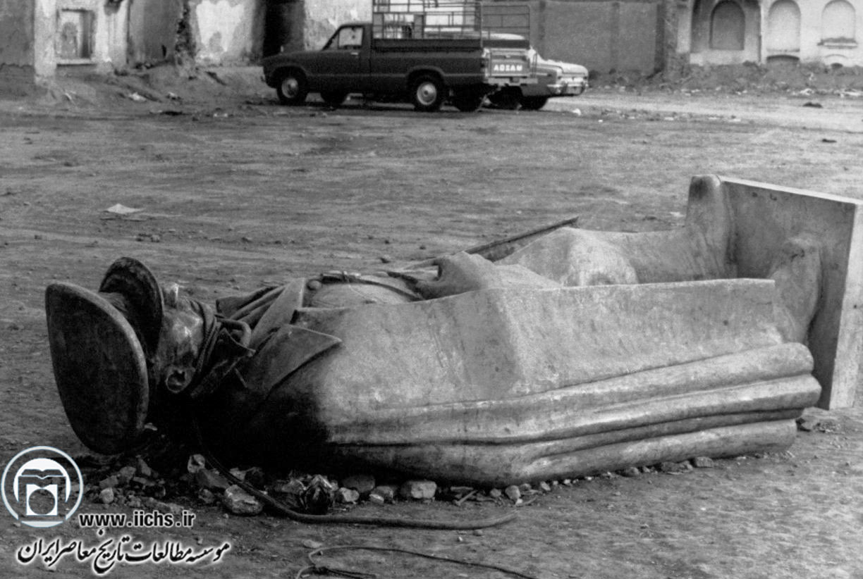 نمایی از تندیس سرنگون‌شده محمدرضا پهلوی که به یکی از مناطق حومه تهران انتقال یافته است (بهمن 1357)