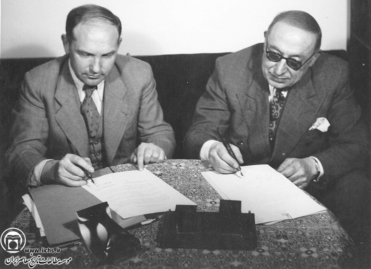 احمد قوام، نخست‌وزیر، و ایوان سادچیکف، سفیر شوروی در ایران، در حال امضای موافقتنامه 