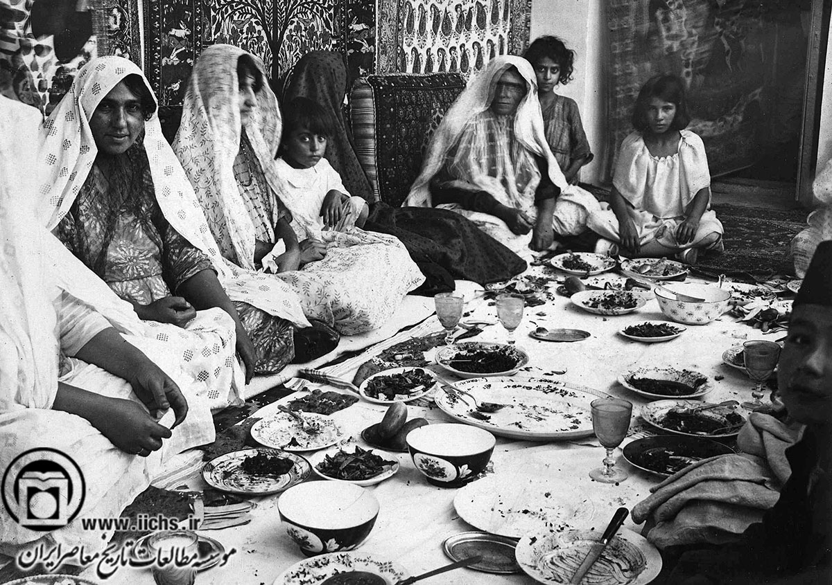 زنان و کودکان عضو یک خانواده ایرانی بر سر سفره  نهار در اوایل دوره پهلوی