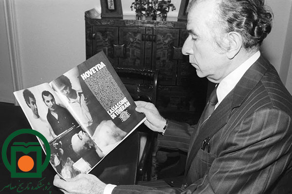 فریدون هویدا به عکسی از جنازه برادرش امیرعباس هویدا، منتشرشده در یک مجله فرانسوی، نگاه می‌کند