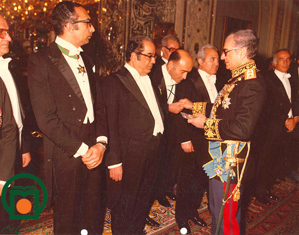 محمدرضا پهلوی در حال توزیع سکه بین مدیران و رؤسای ادارات بنیاد پهلوی در یکی از سلام‌های رسمی